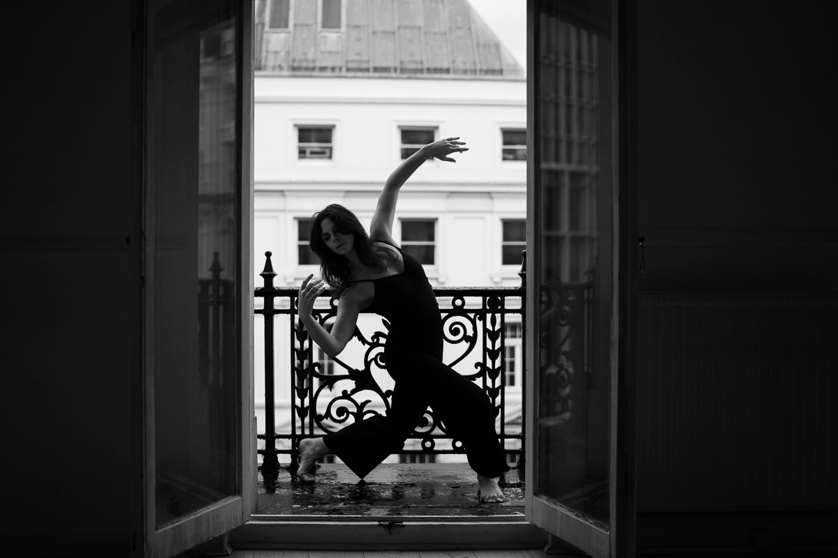Dancer in graceful pose on an ornate balcony